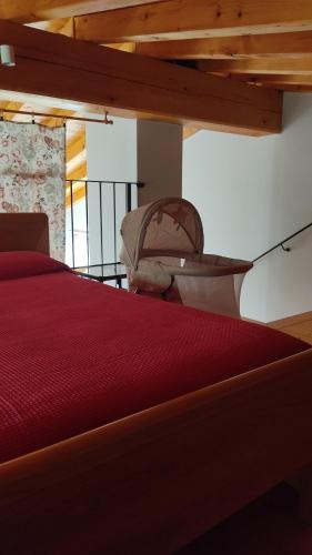 a bedroom with a red bed and a wooden ceiling at Appartamento Cristol in Gargnano