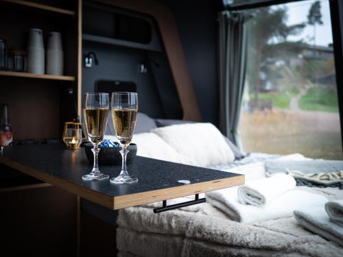 twee glazen champagne op een tafel in een slaapkamer bij Aurora Igloo Porvoo in Porvoo