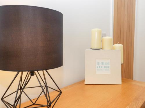 a black lamp sitting on a table next to candles at The Milking Parlour in Cranbrook
