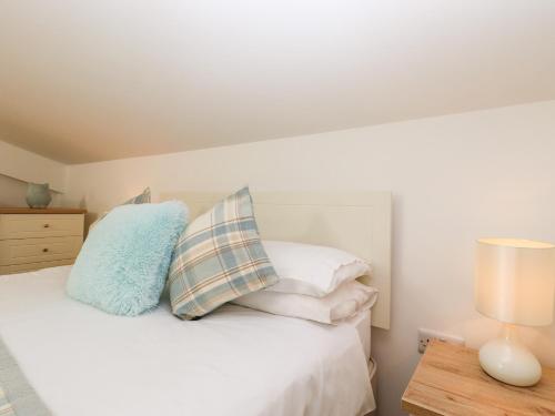 a bedroom with a white bed with pillows and a table at The Milking Parlour in Cranbrook