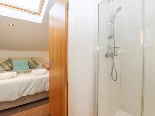 a bathroom with a shower and a bed at The Milking Parlour in Cranbrook