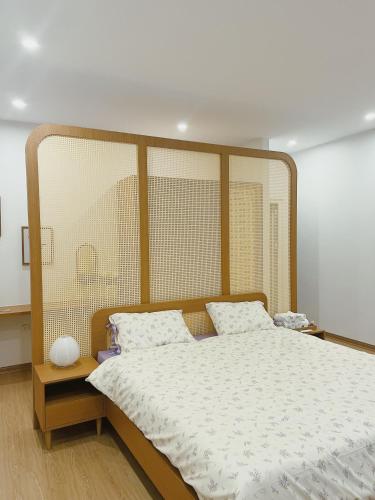 a bedroom with a large bed with a wooden headboard at 1.Hôme in Hanoi