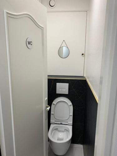La petite salle de bains est pourvue de toilettes avec une porte ouverte. dans l'établissement Chambre Privée Face arrêt de Tram proche métro 5 Pablo Picasso, Chambres individuelles , La cuisine , le WC et la salle de bain sont en commun, à Bobigny