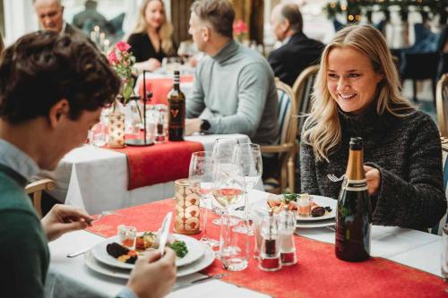 grupa ludzi siedzących przy stole jedzących jedzenie w obiekcie Säröhus Hotel, Conference & Spa w mieście Särö