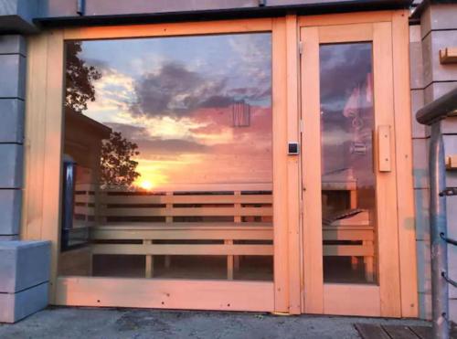 a glass door with a reflection of a sunset at Apartmán - F - Vyhlídka nad řekou in Zdiby