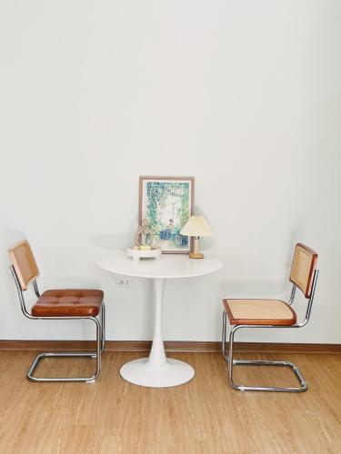 a white table with two chairs and a table with a lamp at 1.Hôme in Hanoi