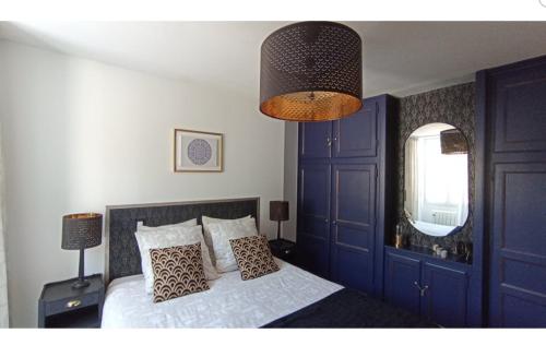 een slaapkamer met een bed met blauwe kasten en een kroonluchter bij L'Étape du Tourmalet in Luz-Saint-Sauveur