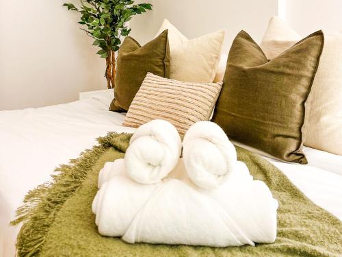 two towels on a bed with pillows at Voyage Studio In Waters Edge in Abu Dhabi