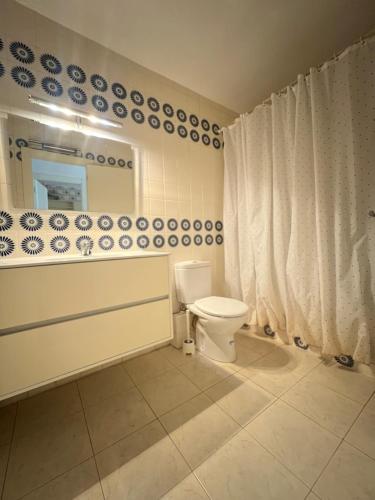 uma casa de banho com um WC e um espelho. em Costa Daurada Apartaments - MURILLO III em Salou