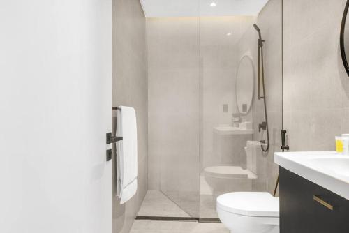 La salle de bains est pourvue de toilettes et d'une douche en verre. dans l'établissement Meerak Homes - Glamorous 2 bed Apartment with Panoramic Views - Business Bay with free Wifi, Parking, Gym and Pool, à Dubaï