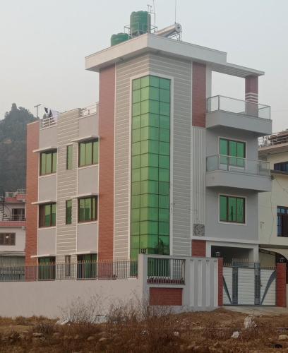 a building with green glass windows on it at Chandragiri Apartment in Khokna