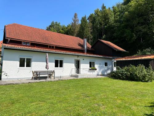 a white house with a picnic table in a yard at Salzkammergut Homes Gmunden - Haus im Grünen, Ruhe, großer eingezäunter Garten - ideal für Familien und Hunde in Pinsdorf