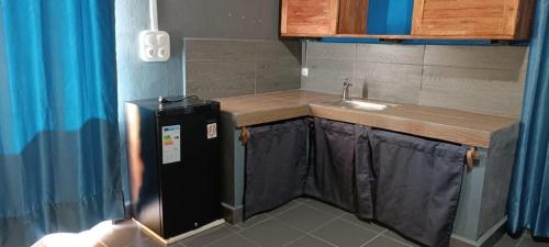 eine kleine Küche mit Spüle und Kühlschrank in der Unterkunft Studio Familial (AMI Appart-Hotel) - Taolagnaro in Tolagnaro