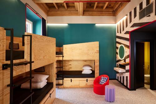 Cette chambre comprend 2 lits superposés et une chaise rouge. dans l'établissement JO&JOE ROMA, à Rome