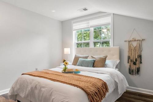 a white bedroom with a large bed with a window at Amazing Chesapeake Views Family getaway 4brms in Chesapeake Beach