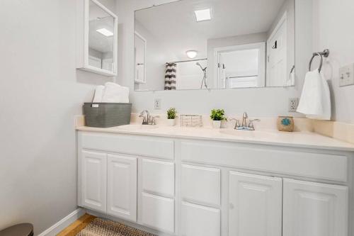 a white bathroom with two sinks and a mirror at Amazing Chesapeake Views Family getaway 4brms in Chesapeake Beach