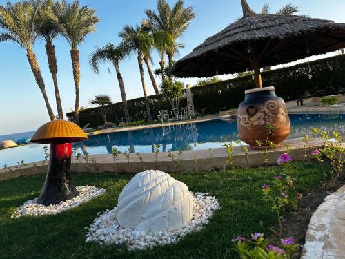a garden with an umbrella and a large white ball at Casa Del Sol in Sharm El Sheikh