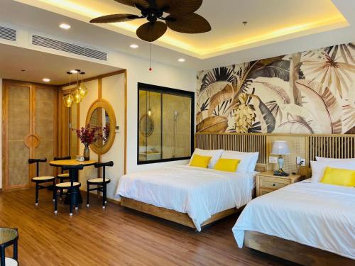 una camera d'albergo con due letti e un tavolo e una sala da pranzo di Hanie Apartment - FLC Sea Tower Quy Nhon a Quy Nhon