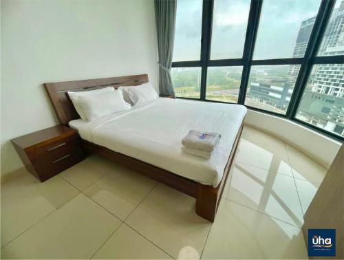 a bed in a room with a large window at Macrolink Medini by RR JBcity in Nusajaya