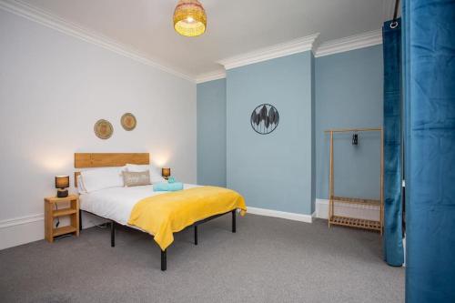 um quarto com uma cama com um cobertor amarelo em BayleafStay Seaham em Seaham