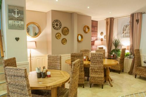 uma sala de jantar com uma mesa de madeira e cadeiras em The Belgrave Hotel Tenby em Tenby