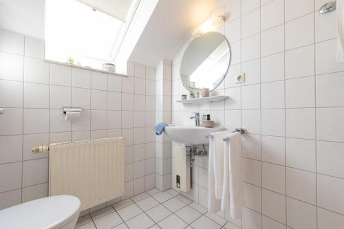 a white bathroom with a sink and a mirror at LM3-33 - Ferienwohnung Typ AB Komfort in Schottwarden