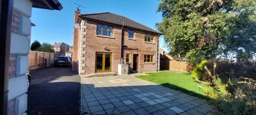 a brick house with a driveway in front of it at Large private detached home in Dungiven