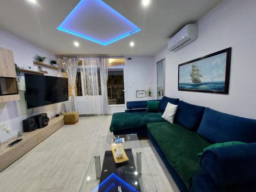 een woonkamer met een groene bank en een tv bij Apartman Annely in Pirovac