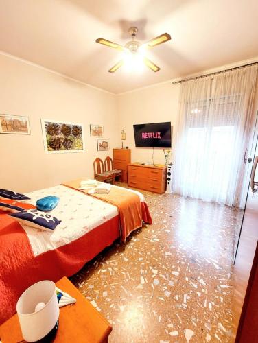 a bedroom with a bed and a flat screen tv at WHOLE FLAT CLOSE BEACH BREAKFAST KITCHEN AIR CONDITIONING LAUNDRY SHUTTLE AIRPORT WI-FI CAR PARKING NETFLIX BALCONIES CHECK IN 24H & METRO to ROME in Lido di Ostia