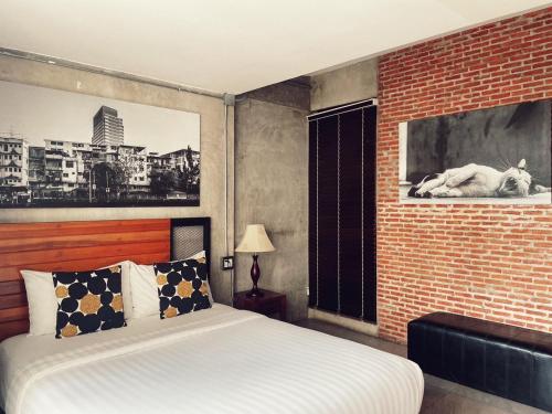 a bedroom with a bed and a brick wall at Yotaka The Hostel in Bangkok