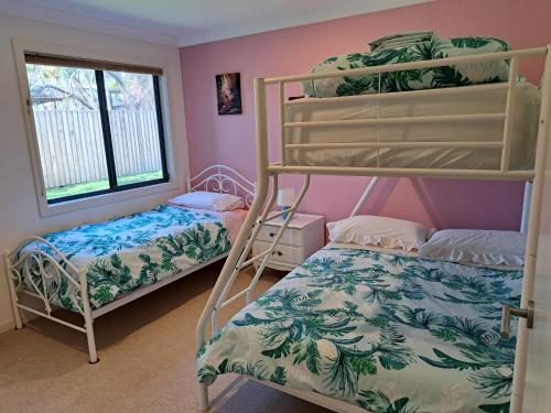 a bedroom with two bunk beds and a window at Paradise by the Bay in Callala Bay