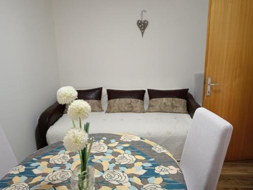 una mesa con flores y un sofá en Karic apartman, en Paraćin