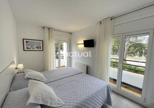 ein Schlafzimmer mit einem Bett und einem großen Fenster in der Unterkunft LAS PALOMAS 1-2 in Platja  d'Aro