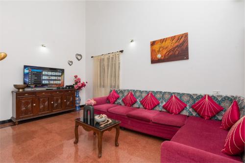 a living room with two purple couches and a tv at Villa Calangute Phase 4 in Calangute