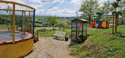 - un parc avec une aire de jeux dotée d'un banc et d'équipements de jeux dans l'établissement Camping Le Bourdieu, à Durfort