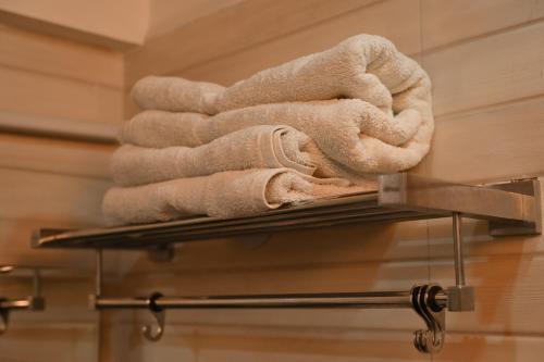a pile of towels on a towel rack in a bathroom at Hotel DH in Dharamshala