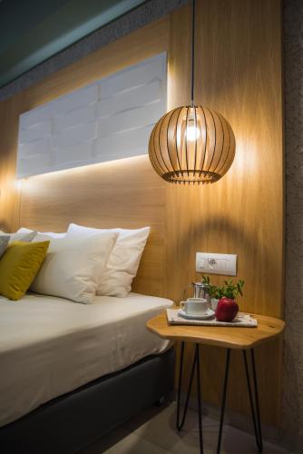 a bedroom with a bed with a table and a lamp at Sunshine Boutique Hotel by Estia in Malia