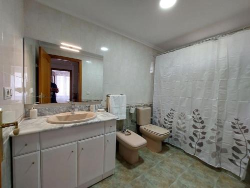 bagno con lavandino, servizi igienici e specchio di Vistas al mar en Canet Playa WIFI a Canet de Berenguer