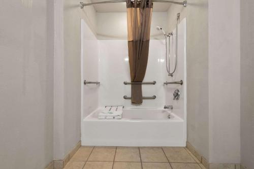 Rodeway Inn & Suites Tomahawk في توماهوك: حمام مع حوض استحمام مع دش