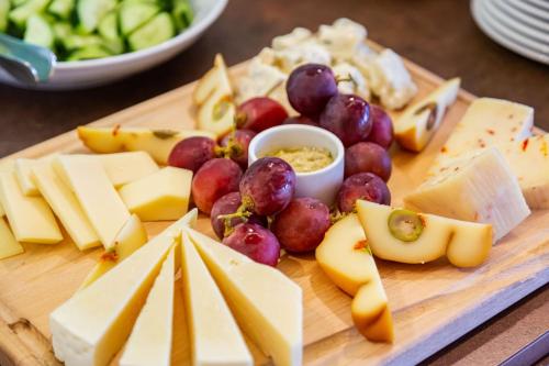 a cutting board with cheese and grapes and other foods at Best Western Hotel La Solara in Sorrento