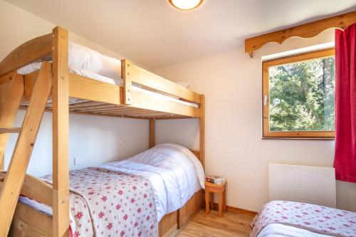 a bedroom with two bunk beds and a window at Au Bon Air - Appt au pied des pistes in Chamrousse