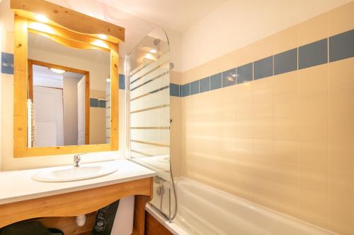 a bathroom with a sink and a tub and a mirror at Au Bon Air - Appt au pied des pistes in Chamrousse