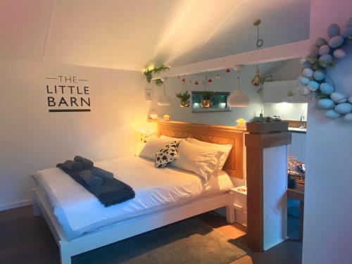 a bedroom with a white bed with a sign on the wall at The Little Barn in Hoxne