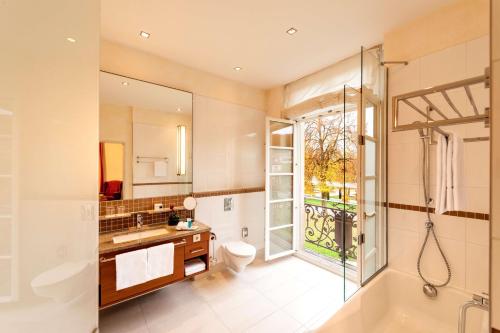 ein Badezimmer mit einer Badewanne, einem Waschbecken und einem WC in der Unterkunft Dorint Resort & Spa Bad Brückenau in Staatsbad Brückenau