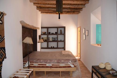 a bedroom with a large bed in a room at DAR SOKASA Riad authentique et contemporain in Aït Skouala