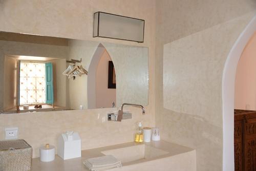 a bathroom with a sink and a mirror at DAR SOKASA Riad authentique et contemporain 