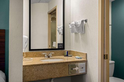 a bathroom with a sink and a mirror and a toilet at Sleep Inn in Wilmington