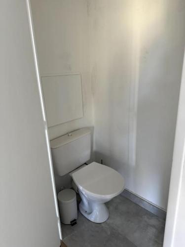 uma casa de banho com um WC branco num quarto em Appartement neuf avec balcon et parking privé em Caen