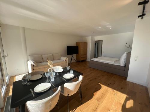 ein Wohnzimmer mit einem Tisch, Stühlen und einem Sofa in der Unterkunft Urban Lodges - Studio Apartments am Seerhein in Konstanz