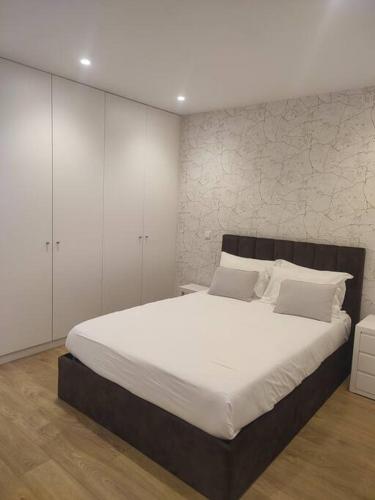 una camera da letto con un grande letto bianco e armadi bianchi di Braga Center Apartments - São Vicente 78 a Braga